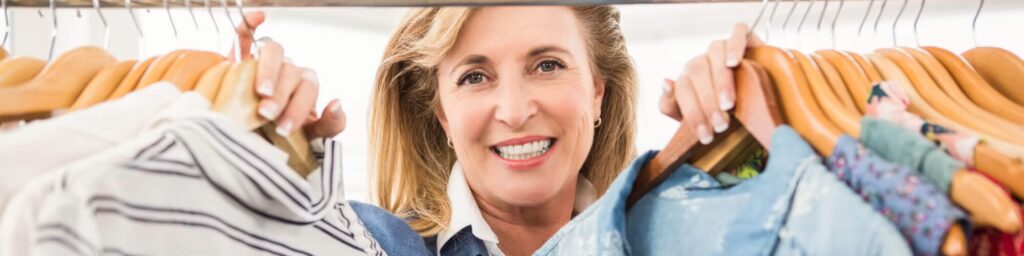 woman in closet looking at outfits
