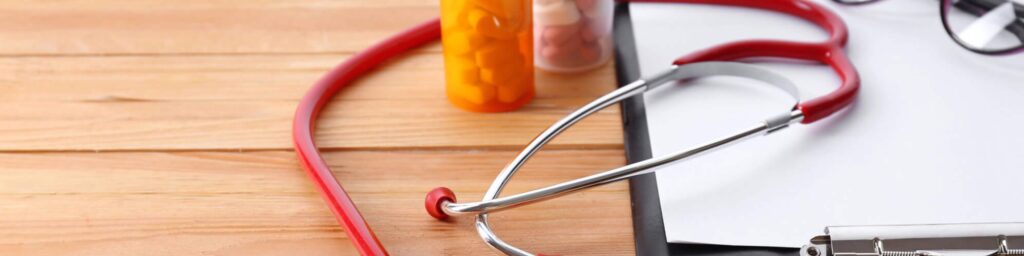 stethoscope prescription bottles clipboard on desk