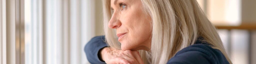 sad worried woman looking out window