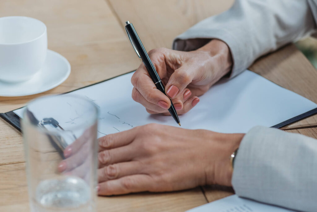 woman writing at desk brainstorming what to do next for work