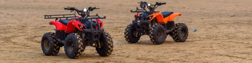 two red all-terrain verhicles (ATVs) in sand dunes