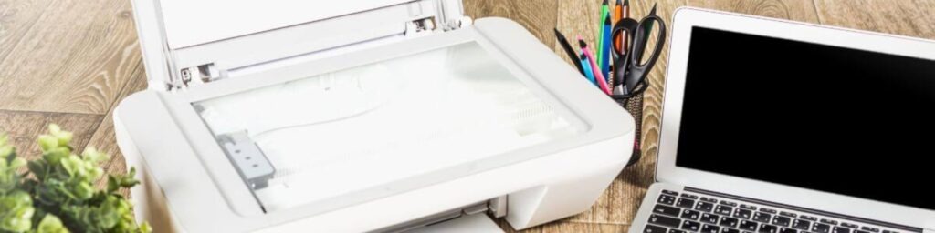 printer laptop and office supplies on desk