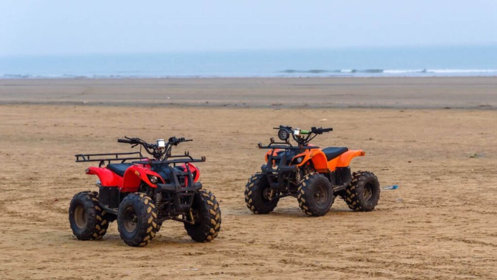 two all-terrain vehicles on a beach