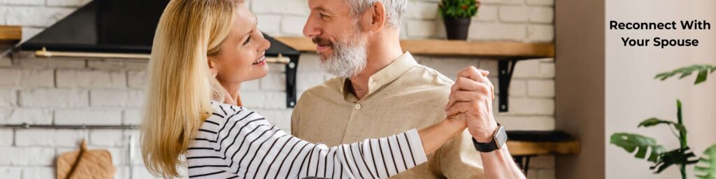 middle-aged couple reconnecting by dancing in kitchen
