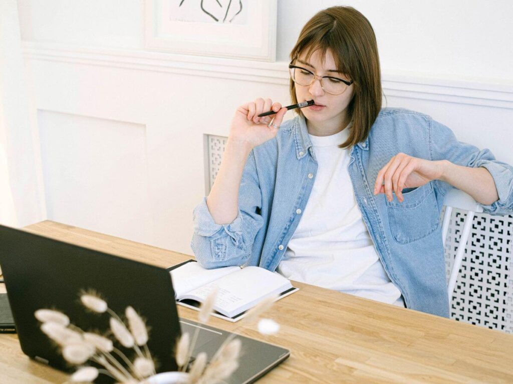 woman sitting a table with journal thinking about what she will do now that kids are gone