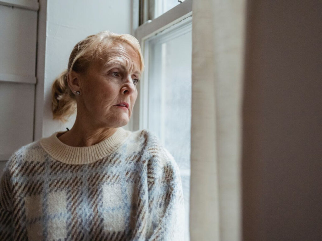 lonely empty nester mom looking out window